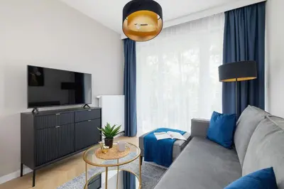 a living room with a couch and a tv at Klimatyzowany Apartament w Centrum Krakowa z Parkingiem i Biurkiem by Renters Prestige in Kraków