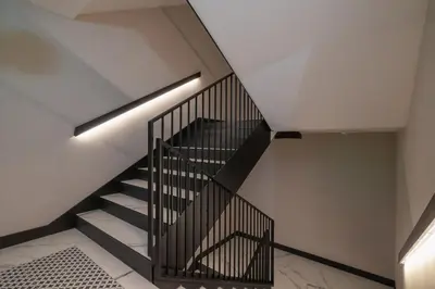 a staircase with black railings in a house at Klimatyzowany Apartament w Centrum Krakowa z Parkingiem i Biurkiem by Renters Prestige in Kraków