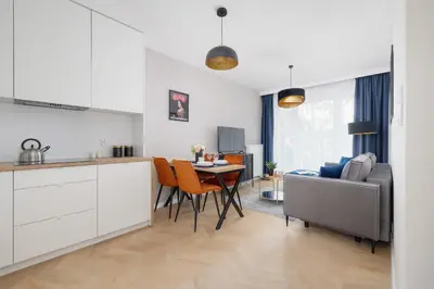 a kitchen and living room with a table and a couch at Klimatyzowany Apartament w Centrum Krakowa z Parkingiem i Biurkiem by Renters Prestige in Kraków
