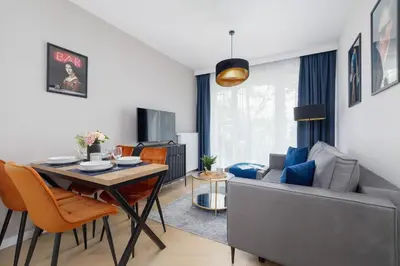 a living room with a table and a couch at Klimatyzowany Apartament w Centrum Krakowa z Parkingiem i Biurkiem by Renters Prestige in Kraków
