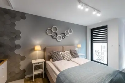 a bedroom with a bed with a gray wall at Rajska 3 Grey Apartment Krakow City in Kraków
