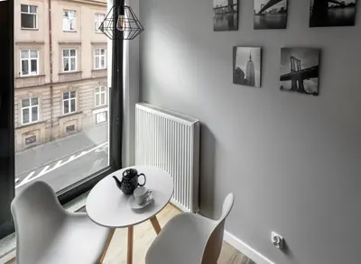 a white table and chairs in a room with a window at Rajska 3 Grey Apartment Krakow City in Kraków