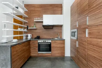 a kitchen with wooden cabinets and a counter top at Malila Premium Apartments Cracow City Center Grodzka 50 in Kraków