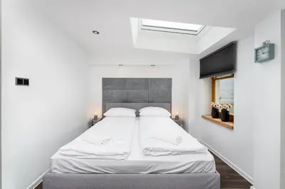 a bedroom with a large white bed with two pillows at Malila Premium Apartments Cracow City Center Grodzka 50 in Kraków