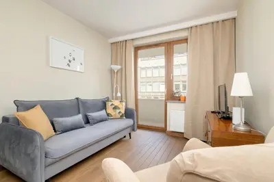 a living room with a blue couch and a television at Centrum Krakowa Piękny Apartament z Balkonem by Rent like home in Kraków