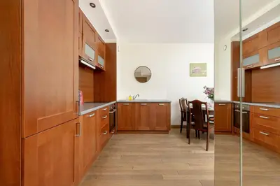 a large kitchen with wooden cabinets and a table at Centrum Krakowa Piękny Apartament z Balkonem by Rent like home in Kraków