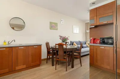a kitchen and a dining room with a table at Centrum Krakowa Piękny Apartament z Balkonem by Rent like home in Kraków