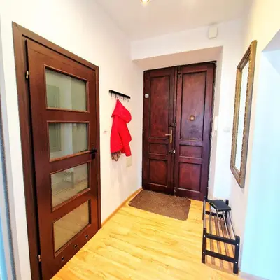 a hallway with a door and a red shirt hanging on the wall at Old Town Apartments - B6A in Kraków