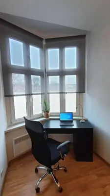 a desk with a laptop on it in front of a window at Old Town Apartments - B6A in Kraków