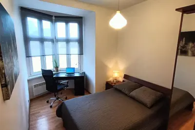 a bedroom with a bed and a desk and a window at Old Town Apartments - B6A in Kraków