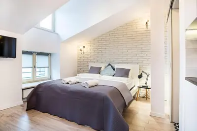 a bedroom with a large bed and a brick wall at Old Town Apartments - T36a in Kraków