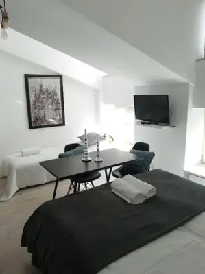 a living room with a table and a bed at Old Town Apartments - T36a in Kraków