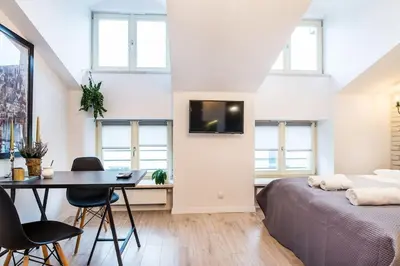 a bedroom with a bed and a desk and a table at Old Town Apartments - T36a in Kraków