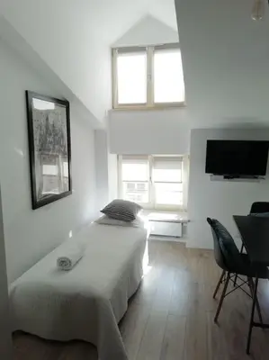 a bedroom with a bed and a flat screen tv at Old Town Apartments - T36a in Kraków