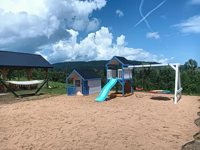 a playground with a slide in the sand at Przystanek Modyń in Młyńczyska