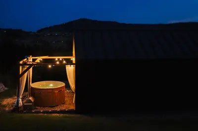 a bath tub sitting in a gazebo at night at Przystanek Modyń in Młyńczyska
