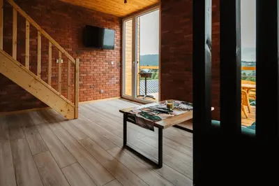 a living room with a table and a staircase at Przystanek Modyń in Młyńczyska