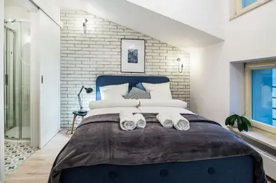 a bedroom with a large bed with towels on it at Old Town Apartments - T36b in Kraków