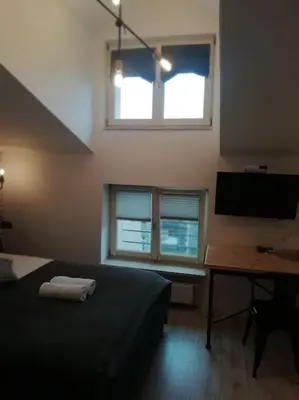 a bedroom with a bed and a desk and a television at Old Town Apartments - T36b in Kraków