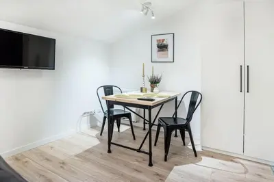 a dining room table with four chairs and a tv at Old Town Apartments - T36b in Kraków