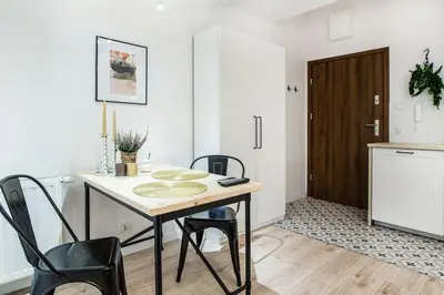 a kitchen with a table and chairs and a door at Old Town Apartments - T36b in Kraków