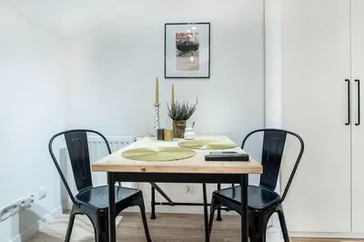 a dining room table with four chairs and a candle on it at Old Town Apartments - T36b in Kraków