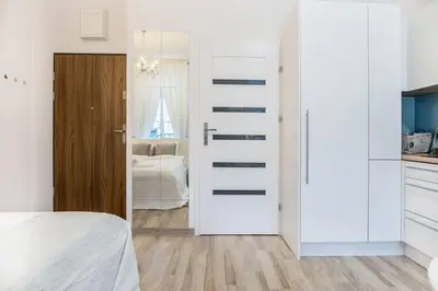 a bedroom with a door leading to a kitchen at Old Town Apartments - T32 in Kraków