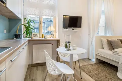 a kitchen and living room with a table and a couch at Old Town Apartments - T32 in Kraków