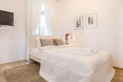 a white bedroom with a white bed and a window at Old Town Apartments - T32 in Kraków