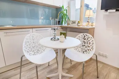 a kitchen with a white table and two chairs at Old Town Apartments - T32 in Kraków