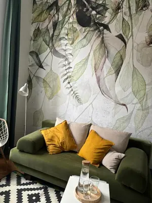 a living room with a green couch and a mural at Krakow Central Green Apartments in Kraków