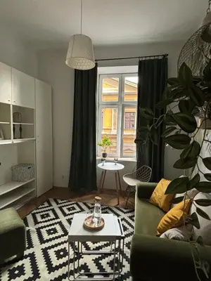 a living room with a couch and a table at Krakow Central Green Apartments in Kraków