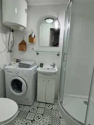 a bathroom with a washing machine and a sink at Krakow Central Green Apartments in Kraków