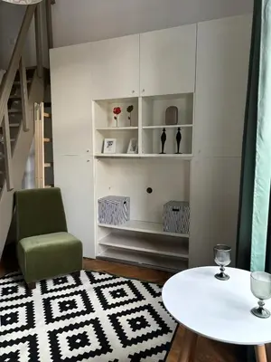 a living room with a green chair and a table at Krakow Central Green Apartments in Kraków