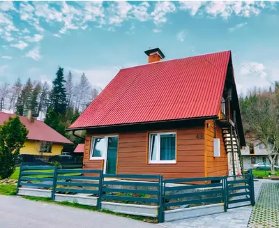 a small wooden house with a red roof at Domek Babiogórka in Zawoja