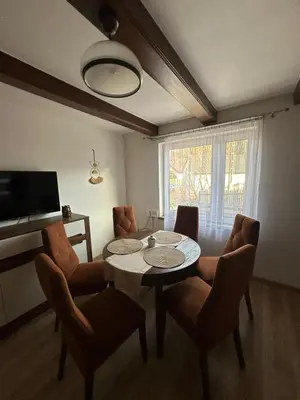 a living room with a table and chairs and a television at Domek Babiogórka in Zawoja