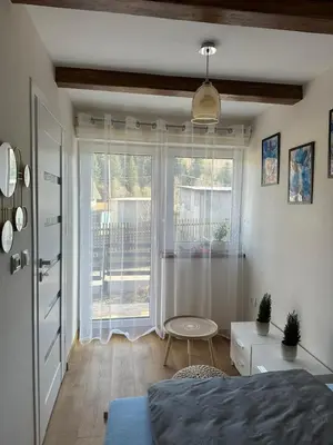 a bedroom with a bed and a large window at Domek Babiogórka in Zawoja