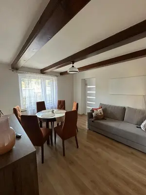 a living room with a couch and a table and chairs at Domek Babiogórka in Zawoja