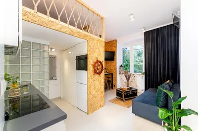 a living room with a loft bed and a kitchen at Lighthouse by Cozyplace in Kraków