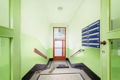 a hallway with a red door in a green building at Lighthouse by Cozyplace in Kraków
