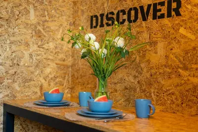 a table with two cups and a vase of flowers at Lighthouse by Cozyplace in Kraków