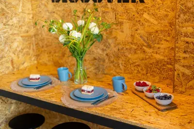 a table with plates of food and a vase with flowers at Lighthouse by Cozyplace in Kraków