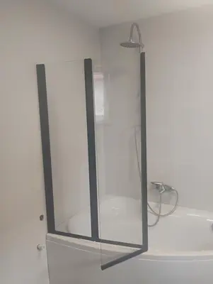 a glass shower door in a white bathroom at Pokoje u Ewy in Limanowa