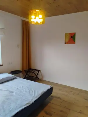 a bedroom with a bed and a chandelier at Pokoje u Ewy in Limanowa