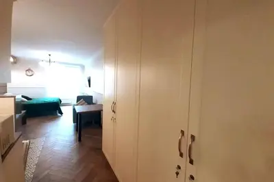 a white cabinet in a room with a living room at Augustiańska Cozy Apartment A9 in Kraków