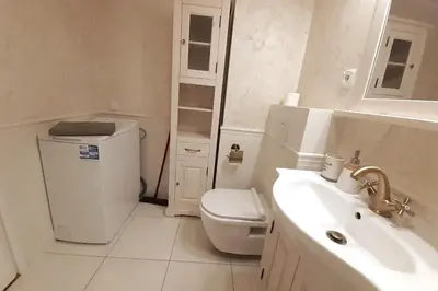 a white bathroom with a toilet and a sink at Augustiańska Cozy Apartment A9 in Kraków