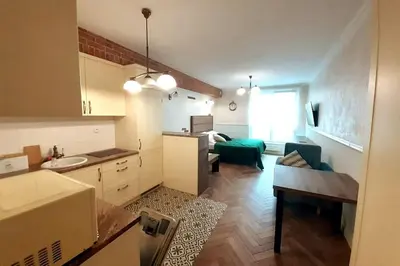 a kitchen and living room with a couch and a table at Augustiańska Cozy Apartment A9 in Kraków