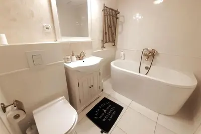 a white bathroom with a toilet and a sink at Augustiańska Cozy Apartment A9 in Kraków