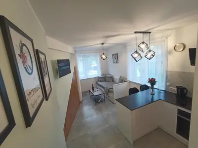 a room with a kitchen and a living room at Apartament Gotowizna in Wadowice