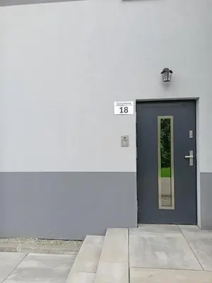 a building with a blue door with a sign on it at Apartament Gotowizna in Wadowice